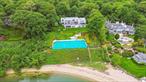 This extraordinary, unrivaled , 10, 000 sq ft waterfront estate sits on 2 private acres with 200 feet of shoreline and direct private beach access, offering breathtaking views of Cold Spring Harbor. With 5 bedrooms, 6.5 baths, and 4 fireplaces, this home delivers unmatched luxury, privacy, and functionality.A newly built enormous entertaining room features dramatic ceilings and a built-in wet barâ€”perfect for hosting on any scale. The chefâ€™s kitchen boasts granite countertops, high-end appliances, three ovens, custom cabinetry, and two dishwashers, alongside a spacious laundry room. The elegant library with a full bath offers flexibility as an additional guest or work space.Upstairs, three en-suite bedrooms each offer private balconies and stunning water views. The primary suite is a true retreat with its own fireplace, double vanities, spa bath, and a huge walk-in closet.The walk-out lower level includes a spectacular indoor pool and hot tub, full bath, an entertainment room with wet bar. The true hidden gem is the separate guest houseâ€”a beautifully appointed living space complete with its own bedroom, living area, and private entrance to paradise.Outdoor amenities include over 1, 800 sq ft of wraparound decking, a tennis court, gazebo, and the ultimate waterfront lifestyleâ€”jet skiing, kayaking, and so much more, right from your own beach.Additional features: whole-house generator, advanced security system, 4+ car garage, and abundant storage throughout.Photos canâ€™t capture the true beauty and scale of this retreatâ€”you must see it in person to believe it. Schedule your private tour today and experience waterfront living at its finest.