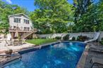 Elegant Douglaston Retreat - A Rare Gem by the Nature Preserve. Welcome to this fully detached Colonial residence in the prestigious enclave of Douglaston. Designed and rebuilt in 2010, with refined taste and modern luxury in mind, this 4 bedroom sanctuary offers a harmonious blend of timeless charm and sophisticated living. Upon entering via the inviting front porch, the open floor plan seamlessly connects the sun-drenched living room with large windows and classic wood burning fireplace to the spacious dining area. There is also a powder room for added convenience. The white chef-inspired kitchen features a central island - perfect for both intimate gatherings and large-scale entertaining. As an added bonus, there is a large den adjacent to the open concept kitchen. Glass doors lead to an expansive granite deck that overlooks your private heated saltwater pool - an idyllic setting for outdoor lounging and summer soirees. The upstairs impresses with custom vaulted ceilings and 4 full bedrooms. The primary bedroom has oversized panoramic windows overlooking the backyard with the serene pool and lush nature preserve. Another bedroom was customized with a delightful loft that has been designed to resemble a ship. The renovated Roman bathroom offers both a soaking tub and a standup shower. The finished walk-out basement has a full bathroom and extends the residence with a versatile space for recreation, fitness or long-term guests. Its attached garage offers space for 2 cars, while the long driveway can fit an additional 3 cars.Tucked alongside a lush nature preserve on a cul-de-sac, this serene property offers unparalleled privacy and access to scenic walking trails - combining luxury living with the tranquility of the outdoors. At the same time, the LIRR station with restaurants and stores is just a couple of blocks away. A rare opportunity ton own a distinctive home in one of Queens&rsquo; most exclusive neighborhoods. Experience the best of suburban elegance with city convenience.