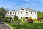 Discover timeless elegance in this beautifully landscaped 5 bedroom custom colonial, perfectly sited in a peaceful, sought after neighborhood. The perfect home for a large or extended family. This home offers the ideal blend of classic architecture and contemporary updates, providing both space and sophistication for modern living. Stone pillars grace the entrance to the property, setting a grand tone as you approach the home. Step inside to discover a spacious two story center hall foyer, leading to the light filled living room and dining room. A gourmet kitchen with stainless steel appliances, a large center island, quartz kitchen counters with a glass tiled backsplash opens to the family room with a gas fireplace. Step out onto the large deck with a pergola and great views of sweeping lawns and woods. Pantry closets, laundry room, two half baths and the garage finish the first floor. There are crown moldings, and recessed lights throughout. Upstairs is a large primary suite with a walk in closet and spa like bathroom. Four other large bedrooms share a newly renovated full bathroom. The partially finished walk out basement adds approximately 1000 extra square feet to the home and there are endless possibilities for this wonderful space. Stone patio, planting beds, stone pillars, specimen plantings and a lush meditative garden showcase the outdoors living spaces. There is a brand new roof, updated mechanicals and town water, sewer and natural gas. Just minutes to schools, shopping, Metro North and commuting routes.