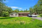 Embrace the ease of single-story living in this peaceful Glen Spey retreat! Tucked away on 1.41 wooded acres with a gentle stream running through the backyard, this 3-bedroom, 2-bath ranch offers the perfect mix of comfort, convenience, and nature. The open floor plan connects the living, dining, and kitchen areas for a bright, seamless living experience. The primary bedroom features its own en suite bathroom with a stand-up shower offering privacy and everyday ease. The primary bedroom also features french doors that lead outside. Step outside to enjoy the very large back deck, ideal for entertaining or relaxing in your private, wooded sanctuary. This home is heat efficiency with it&rsquo;s wood-burning fireplace insert. and foam insulation blown throughout the entire home. Super toasty during the winter. A charming front porch adds to the welcoming feel. You&rsquo;ll also appreciate the attached garage, a spacious driveway with ample parking, and 2 outbuildings/ sheds for extra storage. With no stairs to climb, this home is ideal for anyone seeking single-level living in a tranquil, natural setting. Updates 2020: driveway, siding, roof, living room windows, 2023: blown insulation, laminate flooring throughout.