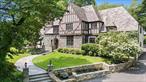 Sophisticated and stylish Edgemont school district Cotswold Tudor is renovated with gorgeous high end modern finishes. This home is located on a beautiful half acre property with stone and brick patios, specimen plantings and lush mature landscaping. You will love the renovated cook&rsquo;s kitchen with custom white cabinetry, Brazilian quartzite counters, Moroccan concrete tile heated floor, high-end Thermador appliances and a cool oversized Lualdi Ferrari red lacquered swinging door from Italy. The grand living room is a wow with floor to ceiling windows, French doors to stone patio, high ceiling, wood beams, and stone fireplace. The first level also features an elegant dining room adjacent to the butler&rsquo;s pantry with coffee bar and wine fridge, inviting den with built-ins overlooking the backyard, cozy home office, exquisite powder room, and incredible entry with Platinum Travertine granite slab floor. The 2nd level offers the expansive primary bedroom with tray ceiling and luxurious spa bath with honed Calcutta marble, heated floor, double sinks, large shower and tub. Two large bedrooms with shared bath, spacious bedroom with en-suite bath, additional bedroom, office, hall bath and back staircase complete the second level. Other highlights include generator, temperature controlled wine cellar, two car garage off kitchen, walk-up floored attic, and lower level with recreation space, powder room, laundry room and storage. Fantastic location close to schools, Scarsdale village, train, shops and restaurants. Don&rsquo;t miss out on this gem!
