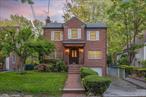 Welcome to 86-49 Dunton Street, a large brick Tudor-style center hall colonial ideally situated on a completely flat 5969 sqft lot in the heart of Holliswood, Queens. This home was fully gut renovated with a large extension in 2003. Distinguished by its unique layout, this home gracefully merges classic architectural integrity with the ease and sophistication of modern living. Inside, the home offers five bedrooms and four full bathrooms.The main level is a blend of traditional formality and open-concept flow, suited for both formal entertainment and daily living. Upon entry, a stately parlor area features a custom-built library, high ceilings, recessed lighting, and a fireplaceâ€”creating the perfect space to entertain over cocktails or dessert. The formal dining room is perfectly suited for large dinner parties; its open concept and recessed lighting create an uncluttered, open space for maximum enjoyment. A notable feature of the dining space is the large, finished, pass-through pantry dividing the kitchen and dining space. Guests won&rsquo;t have to enter the kitchen area for lavatory or handwashing and certainly won&rsquo;t see an active kitchen.The multi-functional chef&rsquo;s kitchen is the heart of this home, not just because of the ambient heated floors throughout, but because of its wonderful layout and large open space. A full-sized eat-in kitchen table, breakfast island, connecting den, and U-shaped cook area create the ultimate family-integrating space. This optimum layout is complimented by a Sub-Zero paneled fridge and freezer, double wall oven, and a built-in extra-large cooktop. A substantial center island with a large area for cook prep or eating is also equipped with a second sink and two dishwashers below. In addition, endless countertops over custom cabinets, window walls looking out to the deck, and two separate pantries top off this kitchen. The main large pantry also features a laundry area for table linens, multiple closets, and a third sink.Impressively, this home features a hacienda-style deck. Seperate to the backyard and front yard, enter seamlessly from the kitchen and enjoy a private yet open-air retreat with ambiant lighting and surround soundâ€”ideal for al fresco dining, barbecuing, or enjoying quiet moments outdoors.Adjacent to the kitchen, a family room provides a relaxed and casual atmosphere. Complete with its own fireplace, custom built-ins, and a window walled door to the private deck. This level also features a full bathroom, a laundry area, and multiple closets.Upstairs, five well-appointed bedrooms line a central hallway complimented by vaulted ceilings throughout. A secondary bathroom has been thoughtfully configured to support shared use, with several separated spaces: a bathtub, a shower, and three vanities. The primary bedroom suite is a serene space distinguished by vaulted ceilings, a walk-in closet, and a spa-inspired en-suite with heated floors, a soaking tub, and a spacious glass-enclosed shower.The fully finished lower level significantly expands this home. This basement was fully extended with the rest of the home. High ceilings, large closets, a full bath, a guest bedroom, and an additional massive open space effectively add a third levelâ€”not just a basement. With its own private entrance and a additional dedicated laundry area, this level functions as an integrated yet independent extension of the home.Situated in the coveted Holliswood neighborhood, known for its tree-lined streets and welcoming community, 86-49 Dunton Street is a rare offering that balances timeless design, thoughtful detail, and everyday livability. A true sanctuary in one of Queens&rsquo; most desirable enclaves.
