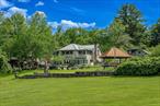 Welcome to Happy Brooks , The much-loved compound for many years of Woodstock Festival co-founder and legendary music industry icon Michael Lang, this mythic Mt. Tremper property boasts true style, along with a creative pedigree that dates back to the 1920s. Originally built for the artist G. Adolph Anderson, the 17 acre estate features three architecturally significant & historic structures designed by prominent architect A.M. Bedell; the original main house was built in 1928, with the two additional & alluring buildings following soon after.The grandly scaled double-height great room of the primary residence has played host to renowned artists of every stripe through the decades, with the inspired design detail easily matched by the world-class art and music created within its impressive walls. In this wing you will also find an office, two powder rooms, upper-level bedroom, and a library. Past a massive bluestone fireplace on the ground floor a central foyer leads into a formal dining room with long-range mountain views, a cooks kitchen with breakfast area, and an open-plan media room (and another massive fireplace with wood stove & built-in bread oven). A light-filled hallway brings you to three oversized bedroom suites, including the romantic, beautifully scaled primary. Behind magnificent stained glass doors you will find a reading room with window seats that overlook the verdant, rolling lawn below. Connecting this wing of the home is a spectacular conservatory with a 24-foot glass ceiling - the perfect place to cultivate plants (or plans), paint a masterpiece, or simply dream.Across the central courtyard, and framed by a wide, mature birch tree is a two bedroom storybook guesthouse that holds true design treasure. An oversized living room leads into a den with bluestone fireplace and a striking collection of built-in Fu dogs and wood-carvings on gilded plaques collected from travels to China that depict an epic story (like the one you can create here). There is also a charming dining area and full kitchen.The third stone and wood structure is a two bedroom cottage that is connected to a three-bay garage, and has a greenhouse ready to be restored or turned into a Romanesque walled garden. Additional structures include a tool shed, three-stall barn, as well as an enchanting picnic pavilion sited up on a knoll with views of Slide Mountain, the tallest peak of the Catskills.From the moment you enter the gates there is a feeling of being in your own private village, and the park-like land is a natural wonder, with winding paths, stone walls, orchards, fields of wildflowers and a large centerpiece pond with its own art island showcasing a sculpture by Michael Lang. On sultry summer days you can enjoy a swim in the 53 x 40 oval lined cement pool while gazing at the peaks and valleys in the distance.Mt.Tremper is located just minutes from main street Woodstock, and Happy Brooks itself is approximately two hours from NYC. This rare Hudson Valley treasure, so full of possibilities, is ready for its next refresh and adventurous steward. So come on and get Happy