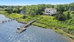 Waterfront Living with Deep Water Dock and Stunning Waterviews!Experience the ultimate in waterfront living with this newly constructed, meticulously designed waterfront home nestled in the charming hamlet of Quiogue. Perfectly positioned between Quogue Village and Westhampton Beach, this shingled two-story residence offers modern amenities, 151 feet of pristine waterfront and stunning bay views from nearly every room. With approximately 3, 400 square feet of elegant living space and additional bonus areas, this home is a rare combination of style, comfort, and functionality. Designed for seamless indoor-outdoor living, the property features expansive water-side decks, inviting porches, and a deep water dock ideal for summer boating, kayaking, and paddleboarding. The main level offers a spacious open-concept layout that captures stunning water views throughout. The gourmet kitchen is outfitted with professional-grade appliances, a walk-in pantry, and a wet bar, and opens to a dining area that comfortably seats up to 12 guests. A cozy gas fireplace anchors the adjacent living room, creating a perfect setting for both entertaining and relaxing. A powder room and an elevator add convenience, while the large waterfront deck-with its motorized awning and spiral staircase-extends the living space outdoors. Upstairs, the luxurious primary suite features dual walk-in closets and a spa-like ensuite bath. Two additional bedrooms share a full bathroom, while a dedicated office space and a laundry room provide everyday comfort and practicality. The walk-out lower level includes a flexible bonus/recreation room that opens to a covered waterfront porch, along with a full bathroom, a one-car garage, a mudroom entry, and generous storage space. Additional high-end features include an elevator servicing all levels, multi-zone hydronic HVAC, in-floor radiant heating, a whole-house fire suppression system, a Sonos sound system, motorized shades, premium Waterworks fixtures, and beautifully landscaped grounds with privacy screening and a full irrigation system. Every detail of this exceptional home has been carefully crafted for modern waterfront living. Whether you&rsquo;re enjoying the serene sunrise views, entertaining guests on the deck, or launching your boat or jet skiis from the private dock, this is a rare opportunity to own a slice of paradise in Westhampton Beach.