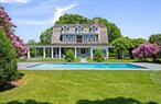 This majestic home originally built in 1881 stands as one of the earliest and most distinguished summer cottages in Quogue. Designed by renowned architect Isaac Green, whose opulent mansions graced Long Island&rsquo;s South Shore during the Gilded Age, this grand residence which was named Bella Mar is rich in both architectural pedigree and cultural history. Among its notable former owners is Tony Award winning director and playwright Arthur Laurents (West Side Story), who, in the 1950&rsquo;s divided the original structure into two residences, the second now next door at 109 Quogue Street. Set on approximately 1.6 acres of impeccably landscaped grounds, this 5, 600+/- square foot three-story home is surrounded by mature plantings and tall privet hedges, offering unmatched privacy. A well-situated gunite pool further enhances the serene estate-like setting. A winding stone drive leads to the expansive front porch and impressive foyer, where 10-foot ceilings set the tone for the interior&rsquo;s scale and elegance. The sun-filled living room and formal dining room, both with fireplaces, create ideal spaces for entertaining. A separate library offers a quiet retreat, while the bright kitchen opens into a charming sun-porch overlooking the peaceful gardens, a tranquil spot to enjoy morning coffee. Central air conditioning serves the main floor, while ductless units provide comfort on the upper levels. A striking staircase, framed by 8-foot stained glass windows with diamond motifs, ascends to the second floor, which features a central landing with fireplace and three generous bedrooms, two of which are en-suite with fireplaces and walk-in closets. The third floor continues the theme of character and charm with tall barrel ceilings, a cozy landing with built-in bench seating, three additional bedrooms, and two baths. Below, the full basement reveals the home&rsquo;s original stone foundation, a testament to its enduring craftsmanship. This is a rare opportunity to own a timeless estate available once in a generation.