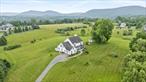 This is the oneâ€”an exceptional and truly special property offering the perfect blend of refined living, natural beauty, and flexibility. Set against a breathtaking countryside backdrop, this Colonial Farmhouse-style home is nestled on just over 5 private, picturesque acresâ€”perfectly suited for horses, weekend escapes, or year-round living. With nearly 4, 800 square feet of thoughtfully crafted living space, this home is designed for both luxurious everyday living and effortless entertaining. Step onto the charming rocking chair front porch and into a home filled with warmth and character. Inside, youâ€™ll find gleaming hardwood floors, central air conditioning, and an easy, flowing layout. A formal living room and a spacious great roomâ€”each with their own inviting ambianceâ€”are divided by a stylish butlerâ€™s pantry featuring granite countertops, ample cabinetry, and pocket doors for optional separation. The formal dining room offers an elegant space for hosting, while the oversized eat-in kitchen is the heart of the home, complete with granite counters, rich hardwood cabinetry, a gas range, large walk-in pantry, and sliding glass doors that lead to a generous deck and bubbling hot tubâ€”all overlooking stunning pastoral views. One of the home&rsquo;s standout features is the private, dedicated in-law suite, with its own full kitchen, separate entrance, and spacious layoutâ€”ideal for multi-generational living, guests, or even a home office retreat.Upstairs, a striking wrap-around indoor balcony offers panoramic views and leads to three exceptionally large bedrooms, each with an ensuite bathroom, as well as a quiet, sunlit office space. The primary suite is a peaceful havenâ€”featuring a luxurious bathroom with elegant quartz accents, a freestanding soaking tub, a beautifully porcelain-tiled walk-in shower with a frameless glass enclosure and rainfall-style shower head, and two-zone heated floors for ultimate comfort. Beyond the bath lies a boutique-style walk-in closet, an entire room devoted to organization, storage, and style. The finished lower level offers over 700 square feet of additional living space, including a cozy sitting area with an electric fireplace, a refrigerator for added convenience, a separate flex room currently used as a fitness area, a powder room and an abundance of storage options. Surrounded by serene vistas, complete privacy, and natural beauty, this home is a true custom retreat. Whether you&rsquo;re seeking peace and solitude, the perfect place for entertaining, or proximity to outdoor adventure, youâ€™ll find it all here. Convenient to the Metro-North Harlem Valley-Wingdale station and close to local treasures including Appalachian Trailheads, area wineries, organic farms, antique shops, hiking, entertainment, and more. This isnâ€™t just a homeâ€”itâ€™s an experience. Come discover your personal escape in the heart of the Hudson Valley.
