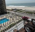 Welcome to the iconic Parker Deauville Penthouse, where coastal luxury meets effortless living in this oversized Junior-4 with sweeping 7th-floor sunrise views and glowing sunset reflections - PLUS Parking! This mint-condition 1, 060 sq ft residence features an ocean view terrace, an open-concept layout, and a designer kitchen with stainless steel appliances and stone countertops, flowing into a flexible dining area that can easily serve as a home office or second bedroom. Wake up to unobstructed ocean views from the serene bedroom, and enjoy an updated bathroom with a sleek walk-in shower, a unit with abundant closet space, and natural light from every window. This premier oceanfront building offers resort-style amenities including a brand new heated pool and oceanfront deck, state-of-the-art gym, party room with full kitchen, direct beach and boardwalk access, security fob video system including a package room under video surveillance,  community library, and ample storage for bikes, boards, umbrellas, and more. Ease your way home with dedicated tandem parking (included in the maintenance), and an assessment of $307.07 through February 2026 for new elevators. This is a special unit to enjoy and experience elevated beachfront living at its finest.