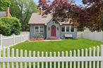 Tucked behind a white picket fence and surrounded by a fully enclosed front and back yards, this 1934 Expanded Cape invites you in with all the warmth and character of a classic cottageâ€”starting at the original arched wood front door that opens into a foyer with a coat closet. Inside, hardwood floors and vintage details blend effortlessly with thoughtful updates, offering a home that feels both timeless and refreshed.The heart of the home flows gracefully from the light-filled living room to the formal dining room, into the kitchen and cozy denâ€”anchored by a charming wood-burning stove, perfect for quiet evenings or intimate gatherings. Sliders off the den lead you into an spacious backyard designed with entertaining in mind: an expansive paver patio, outdoor fireplace, and landscaping create a private sanctuary that feels like your own personal away.With four spacious bedrooms and two full baths, thereâ€™s room for everyone to stretch out. Recent upgrades include a new roof, siding, and Pella windowsâ€”all completed in 2020â€”ensuring peace of mind without sacrificing character. A full unfinished basement offers endless potential, while a detached two and a half car garage adds convenience and additional storage.Whether youâ€™re sipping coffee on the patio or hosting friends beneath the stars, this home offers the kind of warmth, charm, and space thatâ€™s hard to findâ€”and even harder to leave.