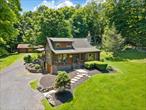TOWN OF CRAWFORD LOG HOME SITUATED ON 25+ ACRES OF SERENE WOODED LAND. This charming 3-bedroom, 2-bathroom log home is situated in the Town of Crawford, within the Pine Bush School District. Conveniently located just 10-15 minutes from local restaurants, shopping centers, and essential services such as banking and postal facilities, this home offers both comfort and accessibility. Surrounded by nature, it is near several parks, including the Crawford Walking Trail and Winding Hills County Park. Major highways, including Route 17K, Route 302, and Interstate 84, provide easy access to Orange County Airport and Stewart International Airport, making travel and commuting effortless. The location is just the start check out the amenities this home has to offer starting with the kitchen combining classic craftsmanship with contemporary convenience. Deep green cabinetry with black iron hardware is complemented by butcher block style countertops, offering both style and function. A farmhouse sink sits beneath a row of large windows, allowing natural light to fill the space while providing a view of the surrounding trees. Exposed log beams and wood-paneled ceilings add to the warm, rustic aesthetic, while stainless steel appliances integrate modern practicality. The open-concept living and dining areas highlight the homeâ€™s impressive architecture. Vaulted ceilings with exposed log rafters create an airy, spacious feel, while large windows frame the natural scenery. The dining space sits beneath a classic chandelier, while the adjacent living area is anchored by a floor-to-ceiling stone fireplace, complete with a wood-burning stove. The natural wood flooring enhances the seamless flow between spaces, emphasizing the homeâ€™s log cabin character. The main level bathroom features a modern-rustic blend of design elements, including a sleek vanity with matte black fixtures, a bold patterned tile floor, and a tiled shower with classic subway tile detailing. Upstairs, the lofted ceilings continue into the bedrooms, where exposed log beams create a distinctive, cozy atmosphere. Large windows allow for ample natural light, while the combination of wood and neutral-toned walls maintains a balanced aesthetic. Plush carpeting provides warmth underfoot, and built-in storage adds functionality to the space. The second bathroom reflects a refined yet rustic style, featuring a modern black vanity, a crisp white sink, and a walk-in shower with elegant marble-patterned tile. The contrast between the wood ceiling and the contemporary finishes gives the space a refined yet cohesive look. The property extends to an expansive backyard, bordered by mature trees for privacy and natural beauty. A secondary outbuilding offers additional storage, workspace options or an additional two car garage. The peaceful setting, combined with the homeâ€™s well-crafted details and thoughtful updates, makes this property a timeless retreat. This will not last long on the market, don&rsquo;t delay, call now for your showing!!!