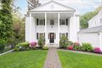 Introducing an attractive and exceptionally well-maintained Greek Revival Colonial home in sought-after Longvale, Bronxville, NY. Pretty as a picture with white columns and sweet open porch, this home offers a perfect layout and commuting convenience. Great curb appeal with professional landscaping and a charming street with a sidewalk for a leisurely walk to town and train, Bronxville MetroNorth, just 31 minutes to Grand Central Station. Upon entering, the heart of the home is the open-concept kitchen and the adjoining formal dining room. The living room hosts a large built-in mirrored china display case, cozy wood-burning fireplace for cold winter nights, and elegant French doors that lead out to a generous scenic deck, complete with a retractable awning. Upstairs features a master bedroom with 2 large closets and a separate full bath. The sunny hallway, with window seat/cedar chest and sunset views, leads to 2 additional bedrooms and a full bath. All bedrooms are fitted with overhead fans and carefully-designed built-in closet organizers. A partially-finished lower-level makes a perfect family room or office, including half bath, 2 large closets, plentiful additional storage, laundry room and glass sliding doors that lead out onto the lower-level deck. Step outside to your own private paradise including a patio, well-manicured lawn, play space, a corner section for gardening, and a cheerful cherry tree that blooms every spring. Also one finished storage unit equipped with HVAC temperature control and a new fully ventilated and wired storage shed. The one car garage, finished inside with epoxy flooring and exterior matching the Greek Revival look, and private paver driveway complete the property. Hardwood floors and central air conditioning throughout. Enjoy a short walk to the vibrant restaurants, coffee shops and up-scale boutiques in Bronxville Village, the many paths, parks, and playgrounds that parallel the Bronx River, and the community feel of the Longvale neighborhood, with holiday parties and friendly lifestyle.