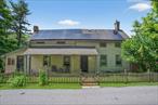 Picture your mountain retreat in this farmhouse built in 1900, blending historic charm with modern potential, set in the scenic Warwick Valley. Just two miles from Sugar Loafâ€™s artisan shops and dining, this 2-bedroom home offers tranquility and an express bus to NYC.. Enter the living room, where exposed beams, hardwood floors, and a fireplace create a cozy feel. Sliding doors lead to a back deck with a heated inground pool and outdoor shower. Host gatherings in the spacious dining room with pine floors. The kitchen features stainless steel appliances, skylights, and a finished side porch for relaxed moments. Upstairs, the master bedroom with hardwood floors is joined by a second bedroom and bathroom. Two car garage with an office on the second floor provides additional space. The private backyard includes a pond, gardens, and a multi-level deck for quiet evenings. Close to shopping, hiking, Greenwood Lake and the Village of Warwick.