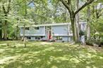 A winner on highly desirable Robin Hood Road! Nestled back on 1.02 acres with mature trees to shade and cool the property is a 2, 592 square foot raised ranch. The light filled entryway leads upstairs to an open flow living area. Living room with vaulted ceilings and wall high windows that allow lots of light. The tiled dining room has a sliding door that leads to a spacious deck with stairs flowing to a larger, lower deck with fencing. Walk through the arched doorway into a beautiful kitchen with an island. Down the hall are 3 bedrooms with a fully tiled beautiful full bathroom, as well as a bathroom with shower in the primary bedroom. Downstairs has an additional 2 bedrooms, and a spacious open area that has a bar island, along with cabinets, a sink and a fireplace. The bathroom on this level has a shower, which is perfect if the additional room downstairs is used as a bedroom. This home has a 2 car garage with convenient entry to the lower level. This gem wonâ€™t last!