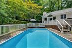 Set on nearly an acre of mature landscaped grounds, this Upper Nyack home offers privacy, style and effortless indoor-outdoor living. A bespoke library with floor to ceiling book shelves and a light filled south facing family room addition,  brings architectural interest, complemented by natural wood finishes, cathedral ceilings and a wood burning fireplace. Beautiful hardwood floors run throughout the first level . Featuring 4 /5 bedrooms and 3 baths including an ensuite primary this layout is both spacious and functional. Outside an in-ground pool and huge deck anchor the tranquil backyard, ideal for entertaining or unwinding. Just minutes from Hook Mtn State Park, River Hook and scenic nature trails this property blends unique design with a connection to nature. Upper Nyack Elementary and Clarkstown pools and parks. All this and only a 45 minute drive into mid-town Manhattan.