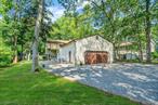 Welcome to 425 Puritan Drive, Shirley! This expansive five-level split was custom built with exceptional attention to detail and showcases true pride of ownership. Situated on a beautifully landscaped half-acre lot with partially wooded surroundings, the home offers park-like grounds and ultimate privacy. Enjoy peaceful mornings and relaxing evenings on the charming covered front porch or beneath the custom-built pergola. The main level features a welcoming foyer, spacious eat-in kitchen, formal dining room, and cozy living room with a fireplace. A half bath, laundry room, and direct access to the two-car garage complete this levelâ€”which also leads to the expansive circular driveway for added convenience and curb appeal. Upstairs, the second level boasts a luxurious primary suite complete with two walk-in closets, an additional closet, and a full ensuite bath. Two additional generously sized bedrooms and a full bath complete this floor. Continue to the upper level, which offers a versatile space perfect for a home office, den, or an additional bedroomâ€”plus a huge walk-in closet. The lower level is ideal for extended living or an in-law suite, featuring a den, a fourth bedroom with a walk-in closet, a third full bath, and a summer kitchen. The basement provides abundant storage, a utility room, and space for a home gym or even more storage solutions. Letâ€™s top off the storage options with expansive attic spaces, offering even more room for your belongings. Recently refreshed with all-new carpeting, freshly painted interiors, and wood-look ceramic tile flooring, this incredible home is truly move-in ready. Donâ€™t miss this rare opportunityâ€”as this one wonâ€™t last!