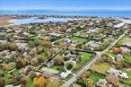 On over two acres, this Village estate is in close proximity to both vibrant Main Street and Dune Road&rsquo;s ocean beaches. Enter the gated estate through a circular drive off Bayfield Lane to the classic Dutch-doored front foyer. There is also a gated service entrance off Stevens Lane. A perfect weekend get-away or a year-round residence, this home boasts an expansive great room with soaring ceilings, exposed beams, and a gas fireplace. The handsome study, with wood-burning fireplace, and sunny all-seasons enclosed porch offer rooms for entertainment and relaxation. The eat-in kitchen has a large center island, ample pantry space, a classic Garland range, and an adjacent mudroom/ laundry room with a separate entrance. A generous primary suite, two additional bedrooms with a shared bath, and a powder room complete the first floor. The second story provides an additional en-suite, along with two more bedrooms with a shared bath. The sprawling hedged property includes mature landscaping, heated gunite pool, and tennis court. Two-lot subdivision is also in progress.