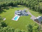 Located just 90 seconds from the heart of Rhinebeck Village and sited at the end of a long, boulder-lined drive, Fieldstone offers unparalleled privacy and proximity. A private oasis set on 31 acres, this masterfully crafted custom modern farmhouse is surrounded by open lawns, pastures, old-growth forest, historic stone walls, and a flowing stream. The light-filled great room dazzles with a soaring ceiling, dramatic beams, clerestory windows and a fireplace with stone hearth. A chefâ€™s kitchen is outfitted with premium Wolf and Sub-Zero appliances, double ovens, induction cooktop, warming drawer, pot filler, double dishwashers, double sinks, and a spacious walk-in pantry. Entertaining is effortless and elegant. Each window showcases a different view of sweeping lawns and lush woods. A sliding glass wall opens seamlessly to a spacious covered porch, blurring the boundary between inside and out. Motorized screens, infrared heaters, and a dedicated pool bathroom offer a resort-like experience. The heated saltwater pool has been sited in such a way to ensure incredible sunset views, while a built-in stone fire pit invites nights of stargazing and fireflies. Four ensuite bedrooms are thoughtfully placed.The private primary suite has a study and access to the screened porch. A finished lower level, as well as a finished bonus second story provide ample space for hobbies, guests and your creative vision. An attached 3-car garage and mudroom make life easy. An Amish-built 60â€™ x 40â€™ pole barn with an unfinished second floor offers endless potentialâ€”room for 8 vehicles, a workshop, studio, or guest quarters. Wander the propertyâ€™s trails to discover a hand-laid stone bridge, scenic overlooks, and a historic sheep herderâ€™s perch. A meandering stream flows gently through wetlands and native flora, adding to the magic.A singular offering where luxury, nature, and convenience converge in perfect balance. Paradise awaits.