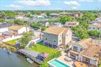 Spacious and beautifully designed waterfront home with spectacular river views and a parklike yard with a brand new bulkhead/retaining wall. This 3, 300 square foot custom home was newly constructed in 2019 on a 6600 square foot lot along the Mill River. Entertain under your large covered patio while watching the boats go by. The river views are even better through the large picture windows in the dining room and a huge connected den on the main floor. The open floor plan adds to the feeling of spaciousness throughout, with a 23 foot eat-in kitchen with wrap-around quartz countertops, an additional breakfast island, and top-of-the-line stainless steel appliances. This main floor also has a half bath and an additional private room that can be used as an office, playroom, or a 6th bedroom/guestroom. Speaking of bedrooms, the second level has five. The master suite has cathedral ceilings and water views, along with 2 large closets and a gorgeous en-suite bathroom with an oversized soaker tub, double sinks, and a separate shower. There are 4 additional bedrooms, another bath and a half, and a laundry room off the main hallway. Additionally, this home comes with plenty of parking, for up to 5 cars in the wrap-around driveway and another 2 in the heated oversized garage with epoxy floor, and another half bath for convenience. Easy access to the LIRR, just a few blocks away.