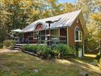 Set on a wooded bluff above the Esopus Creek, this updated 1974 Cape offers Catskills charm, modern upgrades, and a strong connection to the outdoors. A broad 341 sq ft deck welcomes you at the entryâ€”perfect for gathering, grilling, or simply listening to the seasonal stream that borders the property winds down toward the creek below.Inside, the 1, 044 sq ft home features a ground-level bedroom, a great room with bamboo plank floors, and a bay window framing distant mountain views. The open kitchen is fully renovated with custom cabinetry, granite counters, and stainless appliances. A spiral staircase leads to a light-filled mezzanine loft with a window, closets, and space for sleeping, working, or retreatingâ€”currently used as a second bedroom.Improvements include a standing seam metal roof (2005), cedar clapboard siding (2008), rebuilt driveway with stormwater management, as well as newer windows. Tucked against over 130 acres of NY State Forest, this tranquil property blends privacy and proximityâ€”just minutes from Main Street Phoenicia and abundant trailheads nearby.