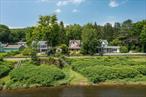 48 River Road, Barryville, NYPrivate Delaware River Access  Historic Charm  Small Town FeelsThey say you canâ€™t step into the same river twiceâ€”but at 48 River Road, you just might want to. With private stairs leading to your own riverfront landing, this Barryville home offers a rare and intimate connection to the Delaware, perfect for tubing, swimming, or simply watching bald eagles glide overhead.The front porch is made for morning coffee with river views, while the rear deck is designed for summer gatherings. French doors open from the chefâ€™s kitchen, where thereâ€™s space to cook, prep, and entertain at the expansive island that is perfect for gathering with friends while the host puts the finishing touch on dinner. A built-in dining nook adds charm, and the formal dining room offers room for a large table, bar area, and woodstoveâ€”ideal for cozy nights in cooler months. Original woodwork adds warmth and character throughout.The main floor also includes a guest powder room and two distinct living areasâ€”one facing the river with bright light and breezes, the other currently set up as a reading room.Upstairs, the large primary bedroom features curved windows, a walk-in closet, and connects to an additional room, currently used as an office. A second bedroom overlooks the river, and a sitting room facing the water makes an inspiring space for music or work. The spacious bathroom includes a walk-in shower, and the laundry is conveniently located on this floor.The third floor offers an additional bedroom with space for a desk or creative setup, plus a large unfinished attic space for ample storage.Outside, the property features mature landscaping, a detached garage, hot tub, outdoor shower, and a sunny backyard with river glimpses. A garden now sits in the embankment of the old Shola-Barryville Suspension Bridgeâ€” filled with herbs and flowers. The private stairs to the Delaware River are also against the old embankment; itâ€™s just so cool.Lovingly cared for by the same owners for over 40 years, 48 River Road is a rare Catskills retreatâ€”full of history, character, and private access to one of the most beloved stretches of the Delaware River. Just over two hours from NYC, but truly a world away.