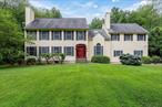Set on a beautifully maintained private one acre, this classic Colonial offers 4 bedrooms and 2.5 bath. Step into a spacious and inviting layout where the entry opens to a bright living room filled with natural light. A wood-burning fireplace serves as a cozy focal point, perfect for relaxing evenings or gathering with loved ones. The formal dining room provides a refined setting for hosting family meals or entertaining guests with ease and elegance. A comfortable family room also featuring a wood burning fireplace provides a warm atmosphere for relaxing and unwinding. The eat-in kitchen is equiped with sleek high end stainless steel appliances, all less than two years old, and custom cabinetry offering both style and efficiency. Sliding glass doors off the kitchen lead out to an large freshly painted deck overlooking an expansive level backyard. Upstairs finds the primary bedroom, featuring striking beamed ceilings that add character and warmth, a generous walk in closet and an en-suite bath. Three additional bedrooms, a full hall bath, and a convenient washer and dryer complete the second level. The unfinished basement offers plenty of storage and endless potential to create additional living space, a home gym, workshop, or whatever suits your needs. Fantastic location with close proximity to major roadways and shopping.