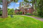 Step back in time to the Jazz Age with this exquisite vintage 1920â€™s Tudor, ideally situated on a sprawling, verdant lot. This 5 bedroom residence proudly preserves a wealth of original details, offering a glimpse into a bygone era of elegance.Entertain in the grand living room, where a magnificent wood-burning fireplace with a hand-carved mantle invites intimate gatherings and a charming book nook promises quiet contemplation. Leaded glass windows cast a soft glow, and French doors open onto a stone-covered patio, a masterpiece of arches and intricate brickwork, perfect for al fresco soirees. Adjacent, the sunroom, with its wide plank floors and sliding glass door, leads to a wooden deck overlooking an expansive yard, complete with a dance patio for lively evenings.The formal dining room, ideal for grand dinner parties, flows seamlessly into a butler&rsquo;s pantry. The kitchen is equipped for modern convenience with an electric range, dishwasher, and double wall ovens. A laundry room is conveniently located off the kitchen, alongside a charming breakfast room and a powder room.Ascend to the second level, with 4 bedrooms and 2 full bathrooms. The first large bathroom has two sinks, a tub/shower, and an additional shower. The second full bathroom has a bathtub/shower and linen closet. The king-size primary bedroom is a true sanctuary, featuring an en suite bathroom, ample closet space, and an en suite office + sleeping porch adorned with detailed brickwork â€“ a private retreat for the discerning owner. A dedicated back staircase from the kitchen leads to a sitting room/lounge.The walk-up third floor offers a versatile space, perfect for a lively hang-out area, an additional private office, and abundant unfinished storage & cedar closet.The lower level provides a spacious recreation room, extensive storage solutions, a half bathroom, and an oversized two-car garage, completing this unparalleled offering of Gatsby-era charm and modern comfort.Easy walk to school, train and Hartsdale. Come live the life!