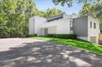 This pristine contemporary gated home, designed by Myron Shulman, is one of a kind. The natural light filled entry level has double height ceilings in the great room with a seamless flow for indoor to outdoor entertaining. The first-floor primary with ensuite has a private deck that overlooks the mature landscape of the backyard. Also, on the first floor is a bedroom/office that has a full bath to service the first floor and the 25x50 heated salt water gunite pool. The second level has two bedrooms, one with a private balcony, that share a bathroom. The lower level is fished with additional living space and a gym. Just minutes to Sammy&rsquo;s Beach and Three Mile Harbor, this home is a perfect get away.