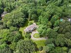 Tucked away on a quiet and private street in the village of Old Brookville, this modern Colonial sits on 2.61 flat acres and offers generous space, natural light, and a flexible layout suited to todayâ€™s lifestyle. The home features seven bedrooms, four full and two half bathrooms, with a grand two-story entry that opens to sun-drenched living areas, a first-floor primary suite, and large windows throughout that enhance the homeâ€™s contemporary feel. The fully finished lower level, with its own living room, kitchen, wet bar, two additional bedrooms, and space for a gym or entertainment area, offers ideal guest or additional living space. A three-car garage connected by a covered breezeway adds both convenience and character to this exceptional property.