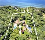 Exquisite Tuscan-Inspired Estate Just Steps from the Beach. A rare opportunity to own an extraordinary Italian Tuscan-style estate, offering timeless elegance and modern luxury on nearly 5 private acres. Spanning approximately 13, 000 sq ft, this 8-bedroom masterpiece is a harmonious blend of Old-World craftsmanship and contemporary sophistication.Enter through a Belgian block-lined driveway to a serene courtyard with tranquil fountains, setting the tone for what lies within. Soaring ceilings, hand-carved wood accents, and arched doorways lead to gracious living and entertaining spaces. A chefâ€™s dream kitchen features high-end appliances, and custom cabinetry ideal for both intimate dinners and grand gatherings.Enjoy seamless indoor-outdoor living overlooking the lush gardens, and an expansive patio surrounding a stunning in-ground heated pool. A separate 3-bedroom guest house offers luxurious accommodations for visitors or extended family!Unwind by one of several fireplaces, or stroll to the beach just minutes away. This estate is smartly equipped with geothermal heating for energy efficiency and also includes a 3-car garage with ample parking.Experience refined living in a setting that feels a world awayâ€”yet is conveniently close to everything. Whether used as a full-time residence or an exclusive retreat, this estate is a true sanctuary where luxury meets lifestyle.