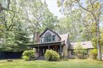 Located just 450 yards from a stunning sandy bay beach, this handsome Cape-style home offers the perfect blend of coastal charm and year-round comfort. The main living room features a cozy wood-burning fireplace, while the kitchen and dining area boast vaulted ceilings that create an open, airy feel. A lovely all-season sunroom overlooks the lush backyard, offering a peaceful spot to relax or entertain. Flexible living spaces feature an office and an art studio, ideal for hosting, working, or creating in comfort. Upstairs, the generous primary suite features a spacious en-suite bath, walk-in closet, and winter water views. The front porch enjoys a view of the generous front yard, dotted with mature trees and specimen plantings. A detached one-car garage offers flexibility for storage.