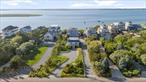 Experience the essence of relaxed coastal living, elevated by timeless design and exceptional rarity, at this unparalleled bayfront compound on Dune Road. Set on .78 acres of pristine waterfront, this private sanctuary offers a lifestyle few properties will ever match. Complete with mooring rights, a secluded bay beach, and deeded right-of-way to the Atlantic Ocean, it is a dream destination for boaters and lovers of nature&rsquo;s finest elements. The main residence invites you in with soaring ceilings, a sun-drenched open-concept layout, and dramatic picture windows that frame the endless expanse of water and sky, creating the sensation of being completely immersed in the elements. A spacious eat-in kitchen flows seamlessly into the living and dining areas and out to a wraparound deck, perfect for entertaining or simply soaking in the serenity. Thoughtfully designed to merge indoor luxury with outdoor splendor, the main house features 4 bedrooms and 3 bathrooms. The entire second level is devoted to the primary suite - a tranquil retreat with panoramic views of both the bay and ocean, a private balcony, and a spa-inspired bathroom that offers elevated privacy and indulgence. On the first floor, a gracious secondary suite with its own en-suite bath is joined by two additional guest bedrooms and a full bathroom, offering both comfort and privacy for family and guests. Outdoors, the property unfolds like a private resort - with a heated gunite saltwater pool, retractable awnings, lush mature landscaping, and a rooftop deck boasting sweeping 360-degree views from ocean to bay. It&rsquo;s the ultimate setting for sunset gatherings, stargazing, or simply escaping the world below. The charming guest cottage features 3 bedrooms and 2 full bathrooms, including a private en-suite. With a proven rental history, it offers built-in value as an income-producing asset or private quarters for extended guests. With subdivision potential, world-class beaches just across the road, and the village of Westhampton Beach mere minutes away, 846 Dune Road represents a once-in-a-generation opportunity to own one of the most distinctive, serene, and versatile waterfront properties on the East End. This is not just a home - it&rsquo;s a legacy.
