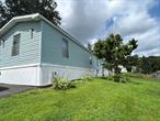 Located in the well-maintained Benwood Knolls Mobile Home Park in Millerton, NY, this move-in ready home offers 2 bedrooms and 2 full bathrooms in a spacious and functional layout. The open-concept living room and eat-in kitchen create a comfortable and welcoming living space, while the primary bedroom with an en-suite bath is privately situated at the rear of the home. A second bedroom at the front is conveniently located next to the main bathroom. Additional features include in-unit laundry just off the kitchen and paved parking. Just minutes from the charming Village of Millerton, this property offers both convenience and comfort. The current lot rent is $446.39 and includes water, garbage and recycling pick-up, septic maintenance, and seasonal road care such as salting, sanding, and plowing.