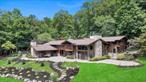 South Mountain Road Paradise! You will be stunned when you drive up to this estate like setting to a Montana style mid century modern chalet inspired by Frank Lloyd Wright architecture, abutting parkland and serenity giving the property total privacy. Imagine sitting on the grand paver patio overlooking the inground gunite pool and seeing your horses enjoy their space. The exterior is spectacular with rock walls, gorgeous fencing, 4 horse stalls, a bonus detached 2 car garage besides the 2 car garage attached to the home. The interior 6200 square feet, boasts of expert workmanship throughout from the rich wood flooring, the genuine stone tiled floors, to all the custom staircases, high ceilings and numerous details. There are 4 fireplaces- a wood burning in the family room off the chefs kitchen with a charcoal stone surround, another brick fireplace in the dining room, a beautiful stone gas fireplace in the great room and the last, a 2 sided gas fireplace in the master bedroom. The kitchen has generous granite counterspace, cherry cabinetry, and high end appliances. This home has 5 bedrooms, 4.5 baths, 2 great rooms, a media room, a finished family room in the basement, a separate wing with the master bedroom, sitting area and built in closet, a screened deck overlooking the property from the upper level, and a reading room near the children/guest rooms.With a distinctive layout that offers both openness and privacy, this home is ideal for those seeking a peaceful year-round residence or a luxurious weekend escape. Every element of this property is custom, unique, and undeniably beautifulâ€”an extraordinary opportunity on South Mountain Road.