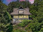 Welcome to â€œThe Tea Houseâ€ a one-of-a-kind architectural sanctuary perched above Gorge Lake in Pound Ridge, where timeless craftsmanship and natural beauty converge in perfect harmony.Rebuilt in 1997 with inspiration drawn from the classic Japanese Tea House, this remarkable estate spans 4.79 acres of private, lakefront land bordered by the protected 738-acre Mianus River Gorge. Landscaped by the renowned Vito Fosella â€” a longtime collaborator of Frank Lloyd Wright â€” the property is a showcase of organic design, dramatic stonework, rare specimen plantings, waterfalls, and tranquil Japanese gardens.The 4, 712 sq. ft. main residence unfolds across three levels and offers four bedrooms and five bathrooms. The entry level opens to a peaceful suite featuring antique handcrafted doors, a fireplace, terrace access, and a luxurious bath with radiant-heated glass tile floors, sauna, and a shared shower connecting to a second full bath and the pool deck.Stairs and an elevator lead to the second level, where a dramatic living room awaits with soaring beamed ceilings, a stunning fireplace, and walls of glass framing seasonal lake and woodland views. The kitchen, open to the living and dining areas, features custom quilted maple cabinetry, granite countertops, and a breakfast bar. French doors on either side of the living and dining rooms extend to a spacious Ipe deck and a fully equipped outdoor Viking kitchen, perfect for seamless indoor-outdoor entertaining.This level also includes another bedroom with a full ensuite bath and private balcony overlooking the heated pool and spa, both managed by an advanced Aqualink system. Every inch of the home is thoughtfully designed to bring the outdoors in while maintaining a sense of peace and privacy.In addition to the main residence, the estate includes two separate guest dwellings. A 1, 200 sq. ft. two-level guesthouse features one bedroom, one and a half bathrooms, a full kitchen with Miele appliances, and a private driveway â€” ideal for hosting in style. A second guest suite, located above the three-car carport, includes a living room and full bath, while a private office space below offers a separate work environment complete with a walk-in wine fridge and half bath.Additional features include a detached three-car garage with an air-conditioned upper level, an elevator servicing all main levels, three backup generators, radiant and hydro-air heat with over 10 zones, a Lutron lighting system, and central air conditioning and vacuum. With multiple Ipe decks, gas-fired spa and pool, landscape lighting, and lake access including a small private island, the property offers both serenity and sophistication.Rarely does a home offer such a blend of architectural integrity, modern convenience, and emotional impact. â€œThe Tea Houseâ€ has served as a personal sanctuary â€” now ready to be passed on to its next discerning steward. Note additional out buildings bedrooms/baths and square footage: Cottage = 1 Bdrm 1.5 bath 570sqftCarport = Studio + Separate office 1.5 bath 1136sqft