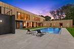 Experience a rare convergence of bold modern architecture and sustainable innovation in this newly constructed estate, perfectly sited on 1.1 acres of private, landscaped grounds. Built from durable concrete and spanning over 9, 000 square feet across three levels, this residence features 8 bedrooms, 8 bathrooms, and 2 powder rooms, designed with an open, column-free layout that maximizes space and light. Wrapped in a super-insulated envelope, and powered by a full solar panel array, the structure can provide enough power to sustain the entire energy consumption of the house. A masterclass in seamless indoor-outdoor integration, the home showcases expansive floor-to-ceiling glass sliders and oversized windows that frame tranquil views and invite natural light into every space. The main level exudes modern elegance with 48 x 48 Italian porcelain tile and textured natural rock, while European oak flooring upstairs adds warmth to the minimalist aesthetic. Anchoring the dramatic great room is a full-height fireplace clad in imported Italian silver travertine, opening directly to a 20&rsquo; x 40&rsquo; heated gunite pool, pool house, and lush garden terraces, all designed for year-round enjoyment and privacy. Architectural design is by DXA Studio and built by XLIX builders with interior design by Atelier Rouje. At the heart of the home is a chef&rsquo;s kitchen by Italy&rsquo;s Arc Linea, featuring fossil-finish European oak cabinetry, Grigio Argentino marble countertops, a full suite of integrated Miele appliances, and a separate prep/butler&rsquo;s kitchen for effortless entertaining. Each of the seven bedrooms offers generous proportions and refined finishes, with the primary suite boasting a spa-inspired bathroom outfitted in Italian porcelain, white Carrara marble, and bespoke Italian fixtures. Additional amenities include a gym, provisions for a sauna, an outdoor kitchen, and a full suite of resort-style features - making this a truly rare modern masterpiece where architectural brilliance meets environmental consciousness.