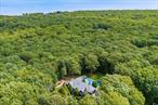 Hampton Bays Chic Residence with Pool, Privacy and Style  Privately sited down a long drive and surrounded by lush landscaping, this turnkey 4-bedroom, 4-bath home offers over 4, 000 SF of effortless living. Inside, soaring ceilings and a sunlit great room with fireplace connect seamlessly to an open kitchen and a screened-in porch. The main level features a serene primary suite along with two additional ensuite bedrooms. The finished lower level expands the living space with lounge areas, bonus rooms, a full bath, and direct yard access. Outside, enjoy the oversized pool, expansive sundeck, and multiple areas to dine, relax, or entertain-all set on 1.28 manicured acres just minutes from Red Creek Pond, bay, ocean beaches, waterfront dining, and vineyards.