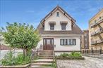 Spacious and updated single-family Colonial on a 40x100 lot in prime Flushing, near the LIRR Broadway station. This 5-bed, 3-bath home features tall ceilings, large windows, and hardwood floors, including original mahogany and oak. The main level includes a formal living room, dining area, full bath, a true first-floor bedroom, plus a rear extension room ideal as a guest suite, home office, or playroom. Upstairs offers a large primary bedroom and two guest bedrooms with access to a private balcony. The finished attic includes bonus space, a full bathroom and storage closets. The finished basement has a separate side entrance, rec room, wet bar, and storage. Updated stucco siding, enclosed front porch, and a paved driveway that fits up to 3 cars with a detached garage. Well-maintained and thoughtfully laid out for extended households or work-from-home needs.