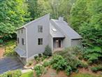 A dramatic and stunning four-bedroom Contemporary home set on 1.2 professionally landscaped acres, designed by Jan Johnsen, former landscape architect for the New York Botanical Gardens. Surrounded by wooded privacy, this serene setting features two separate decks and a ground-level patio that surrounds the exterior of the home. Inside, this home offers a light-filled, modern, and open layout with a seamless connection to nature through its soaring ceilings, skylights, and windows. The main living area features both living and family rooms, separated by a custom wood-burning fireplace and dual access to the large deck that runs along the side of the house. The eat-in kitchen is outfitted with heated floors, soapstone countertops, stainless steel appliances, and direct access to a second deck, ideal for grilling or your morning coffee. A formal dining room, two-story entry foyer, powder room, and a convenient laundry area with patio access complete the first floor. Upstairs, the primary suite includes a walk-in closet and a completely renovated en-suite bath. Three additional bedrooms and another full bath. Additional highlights include hardwood floors, modern brushed nickel switch plates, upgraded interior doors, and modern lighting. Nest cameras and thermostats, roof and skylights (2021). The unfinished basement provides storage or potential for future customization, with direct access to a two-car garage. Located near schools, shops, and just a short drive to the Chappaqua train station, this home offers a rare combination of privacy, space, and modern comfort.