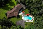 Tucked away on a gently winding country road in the heart of New City, this stately all-brick and stucco residence offers a rare combination of elegance, privacy, and versatility. Set on a full acre of beautifully landscaped grounds, the home spans approximately 4, 300 square feet and is a legal two-family dwellingâ€”ideal for multi-generational living or flexible guest accommodations. A sweeping, open-concept layout greets you upon entry, anchored by a dramatic living room with soaring cathedral ceilings that create a sense of volume and light. The kitchen is both spacious and thoughtfully designed, with ample cabinetry and generous workspaceâ€”perfect for hosting and everyday living. The home&rsquo;s solid construction and classic materials are evident throughout, contributing to a timeless aesthetic that blends form and function. The second-floor living space is perfectly designed to serve as private guest quarters or an independent living arrangement, ensuring comfort and separation when needed. A full, unfinished basement presents tremendous opportunity for future expansion, recreation space, or storage. The oversized two-car garage adds practicality, while the expansive driveway easily accommodates parking for 10+ vehiclesâ€”ideal for entertaining on a grand scale. Outdoors, the home truly shines. The secluded, tree-lined property provides a tranquil backdrop for the in-ground swimming poolâ€”an inviting setting for summer relaxation or festive gatherings. Despite its peaceful setting, the home is just minutes from Exit 11 of the Palisades Interstate Parkway, offering convenient access to commuting routes and all points south. Itâ€™s also close to the revitalized hamlet of New City, where you&rsquo;ll find vibrant restaurants, boutique shopping, parks, and walkable streetscapes. Served by the Clarkstown North School District, this exceptional property offers a compelling combination of size, substance, and location in one of Rockland Countyâ€™s most well-known communities.