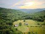 Step back in time and embrace the peaceful rhythms of country living with this extraordinary 1900s farmhouse, gracefully situated on a sprawling 250-acre estate. Rich in history and character, the 2, 700-square-foot home masterfully blends old-world charm with modern-day comfortsâ€”offering a rare opportunity to own a preserved piece of paradise. Thoughtfully restored in the 1990s, the home retains its historic soul while featuring important updatesâ€”most notably to the kitchen and second floorâ€”ensuring comfort and functionality. With four spacious bedrooms and 2.5 baths, the home welcomes you with wide-plank hardwood floors, two cozy wood-burning fireplacesâ€“â€“ one in the living room and another in the kitchenâ€“â€“and a layout designed to celebrate the natural surroundings. A wall of built-in bookshelves adds warmth and personality, while oversized windows fill every room with light and frame sweeping views of the countryside. Just off the kitchen, a sheltered back porch invites you to gather over meals, watch wildlife, or simply take in the peace of the settingâ€”creating a seamless connection between indoor comfort and outdoor beauty. And just uphill from the main house, a field of bountiful blueberry bushes offers one of the propertyâ€™s sweetest seasonal joys: picking your own fruit in the open air, surrounded by nature. Whether you&rsquo;re gathered around the fire with loved ones or enjoying quiet solitude, the heart of the home is both elegant and functionalâ€”perfect for full-time living or unforgettable weekend escapes. The land itself is a sanctuary. Wander through open meadows, ancient woodlands, and along a gentle stream and tranquil pondâ€”ideal for fishing, picnicking, or simply unwinding. Historic stone walls weave through the landscape, echoing stories of generations who once lived in harmony with this land. An authentic old barn provides opportunities for agricultural use, artist studios, or event space. Protected by a conservation easement, this breathtaking property ensures its natural beauty and open vistas remain unspoiled for generations. A haven for artists, naturalists, writers, or anyone seeking privacy, inspiration, and a deep-rooted connection to the outdoors. Whether you&rsquo;re watching the morning mist lift over the hills or stargazing in the stillness of night, this is more than a homeâ€”itâ€™s a legacy, a retreat, and a lifestyle like no other.