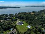 Nestled within the prestigious Village of Sands Point, this stately brick mansion crowned with a handsome slate roof is the epitome of architectural distinction and lasting craftsmanship. A true labor of love, this extraordinary residence was over a decade in the making, with ten years dedicated to its meticulous planning and construction. Encompassing over 20, 000+ Sq.Ft. of thoughtfully curated living space, this impeccable estate offers 8 luxurious bedrooms and 12 elegantly appointed bathrooms, constructed with only top-tier materials.A circular driveway with a gated entry leads to 4+/- acres of lush, manicured grounds that showcase an oversized gunite pool and spa, a covered veranda, an expansive sunbathing patio, and a custom-built pool house with a fully appointed cabana - designed for elevated outdoor living and entertaining.Inside, the home reveals sprawling principal rooms with soaring ceilings, multiple ornate marble fireplace mantels (7 in total), and grand formal entertaining spaces ideal for hosting gatherings of the highest caliber. The chefâ€™s kitchen is a masterclass in luxury and function, featuring bespoke wood cabinetry, thick-cut marble countertops, and a full suite of professional-grade Sub-Zero and Wolf appliances. The palatial primary suite is a private retreat with cathedral ceilings, a sitting room, vanity alcove, boutique-style walk-in closet with a center island, and a spa-inspired bath complete with a generous glass-enclosed shower and soaking tub.Additional features include an attached garage, a rooftop deck, radiant heated floors, an elevator servicing all three levels, a walk-out lower level with a fully equipped theater with surround sound, a matted home gym, and an outdoor grilling station paired with a spacious alfresco dining terrace. Residents of this exclusive enclave enjoy 24/7 village police surveillance, private beach access, and full privileges at the resident-only Village Club of Sands Point, offering tennis and pickleball courts, a swimming pool, and an 18-hole championship golf course. Zoned for the award-winning Port Washington Union Free School District, this estate redefines luxury living on Long Islandâ€™s Gold Coast.