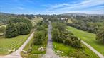 Located just one mile from Sky Acres Airport and approximately 15 minutes from the village of Millbrook, this beautiful and mostly cleared 11-acre parcel in Lagrangeville offers the perfect balance of accessibility and privacy. Positioned at a high point with sweeping views of the Hudson Valley and Catskill Mountains, the property includes the base of a private driveway already in place, complete with cross pipes and large stone material to ensure proper drainage and stabilityâ€”ready for final surfacing. Electric utilities are available halfway up the road, and truck turnoffs have been added to ease construction access. A flat upper landing provides an ideal homesite, perfectly suited for a level backyard, outdoor entertaining space, or pool site. Over 40 mature Norway spruce trees have been strategically planted around the parcel, creating natural screening. Backing to protected conservation lands, this parcel benefits from permanent privacy. This is a rare opportunity to build a custom home or retreat in one of Dutchess Countyâ€™s most desirable areas, surrounded by nature yet close to amenities, schools, and transit options.