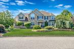 Set on a premium 1.25-acre parcel in Country Manor Estates, this post-modern colonial blends everyday comfort with resort-style outdoor living. Approx. 3, 672 SF above grade with a sunlit, open flow: a 2023 designer kitchen with custom cabinetry, full-height granite backsplash, built-in refrigerator, double wall ovens and electric cook top, center island opens to the breakfast area and great room. Formal living room with gas fireplace and a separate dining room; a full main-floor guest/au-pair suite adds flexibility. Two-story foyer, rich millwork and hardwood floors throughout. Upstairs, the primary retreat offers two walk-in closets and a spa bath with Jacuzzi tub, glass shower and dual vanity, plus four additional bedrooms, an updated hall bath and convenient laundry.Outside, a new driveway (2022) leads to paver walkways and an expansive patio overlooking the free-form waterfall poolâ€”liner 2018, new gas heater 2024â€”framed by mature landscaping and fencing. The walk-out lower level provides a wet-bar lounge, recreation/media zones, a bath and direct patio access for easy indoor-outdoor living.Major updates: new architectural roof 2024, full HVAC replacement 2021, 200-amp electric, central vacuum, full irrigation; natural gas, public water, cesspool. Shoreham-Wading River Schools, close to beaches, parks and village conveniences.