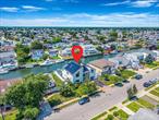 Waterfront Colonial with Unmatched Canal Views & Modern LuxuryWelcome to this exceptional waterfront colonial, perfectly situated on the picturesque Wide Canal. This home blends timeless charm with contemporary upgrades, offering the ultimate in year-round living or the perfect summer retreat.Step into the backyard and take in the breathtaking water views framed by sleek glass railings. Enjoy seamless indoor-outdoor living with a sliding glass door leading to an expansive deck and a gorgeous, surreal backyardâ€”complete with a hot tub and new navy bulkhead for direct access to the wide canal. Its prime location allows easy navigation to the open bay in minutes, with nearby marinas, parks, golf courses, and South Shore beaches just a short ride away.Inside, youâ€™ll find 4 spacious bedrooms and 3 luxurious baths, including a primary suite with a cozy fireplace, a new A/C unit, and a spa-like bathroom with touchless toilets.The thoughtful floor plan includes a laundry room on the second floor, a gas fireplace in the main living area, and even yard access from the bathroom for added convenience.Modern features aboundâ€”central VAC, solar panels, a new roof, an awning for shaded outdoor enjoyment, and a recently upgraded bulkhead for peace of mind. Flood Zone X provides added security without the high insurance costs.Whether youâ€™re looking for a year-round waterfront haven or a luxurious seasonal escape, this home offers the best of Long Island living with Long Island Rail Road access for an easy commute.