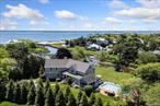 Stunning Remsenburg waterfront with private dock. Situated on 1.15 acres of waterfront property, this custom post modern home, with 4 bedrooms and 3.5 bathrooms, offers multiple living areas with a formal living/dining room with wood burning fireplace, spacious den with gas fireplace, and additional family room adjacent to the kitchen. There are hardwood floors, custom mill work and oversized crown moldings throughout the house. The newly renovated open kitchen features a large center island with seating, stainless appliances including a Viking range, dining area, wet bar with wine fridge and wine rack. Multiple sliders throughout the first floor bring in lots of light and all lead to the deck and backyard oasis. The generously sized second-floor primary suite offers a walk-in closet, gas fireplace, and a private waterside balcony. The adjoining primary bathroom features a double vanity, soaking tub, separate shower, and an additional balcony with water view. The second floor also hosts a separate guest suite with full bath, 2 additional guest bedrooms with a shared hall bath, office/sitting area, and laundry room. The outdoor area offers all the extras for entertaining. Enjoy the oversized heated gunite pool, outdoor fireplace/pizza oven, enclosed screened porch with seating and a private dock for a boat or jet skis. This beautifully landscaped property offers a serene and relaxing experience overlooking the canal.