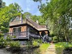 Charming chalet set on a beautifully landscaped acre plus in one of the most sought after areas of Croton-on-Hudson. A private retreat minutes from the Croton Harmon station and fifty minutes into Manhattan. The deck off the master bedroom is nestled in the trees, with a stunning view of the frog pond and surrounding landscape. The Mexican tiled patio room (additional 154 sq ft) offers views of this magical landscape, an entrance into a home with contemporary flair. The formal dining room includes a cedar closet, elegant and functional. Also on the first floor a completely renovated bathroom is tiled and pristine. Completing the first floor is a large, magnificent living room, full of windows, anchored by a new fireplace insert. The new washer/dryer are also closeted on the first floor. Upstairs, the large master suite features a cathedral ceiling, private deck access, and an en suite bathroom with a jacuzzi tub. A bonus: a sauna to relax in for the chillier months. There are two ample additional bedrooms on the second floor. The third-floor loft with skylight and bonus room are ideal for a studio, office, or guest space. Some of the updates include: hardwood floors, ductless a/c heating units, new high efficiency furnace, hot water heater, new insulation and water softener system, new patio doors, and new septic system and well pump. Outside, the property has been extensively landscaped, and a heated detached garage/barn provides a bonus space (additional 336 sq ft) with a range of possibilitiesâ€”from workshop to home gym or studio. Completely private while offering peace and privacy just minutes from the local train station and charming village shops, this one-of-a-kind home is a rare find for Croton and the lower Hudson. There are no audio recording devices inside this property.