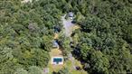 A Rare Opportunity in the Heart of Woodstock. Own a remarkable piece of Woodstock history. Once the site of the Woodstock Lodgeand The Pinecrest, this storied property invites you to step back in time whileenvisioning its next chapter.Set on 6.5 acres of scenic land with a mix of cleared grounds, wooded trails, and aseasonal stream, this property offers a rare combination of privacy and conveniencea short distance from the vibrant village center with its shops, restaurants, andyear-round cultural events.The property includes nine structures plus one foundation, a workshop, and anin-ground pool. Utilities, wells, and septic exist on the property. Property and allstructures, infrastructure being sold as-is/where-is.Currently zoned R3 Residential with potential for residential redevelopment andpossible subdivision, Buyer to due diligence on future use/configuration.