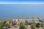 Set on the bay in the coveted hamlet of Remsenburg, 3 Seatuck Lane offers a rare chance to own 75 feet of pristine Moriches Bay frontage with sweeping, unobstructed views. Located south of Montauk Highway and South Country Road, this 3-bedroom, 2-bathroom coastal retreat spans 1, 856 square feet and sits on 0.22 acres, offering a peaceful bay front lifestyle just 75 miles from Manhattan and minutes from the heart of Westhampton Beach. Originally built in 1955, the home combines charming original details with modern comforts. The main level welcomes you with a sunken dining room featuring an inlaid brick floor and wood-burning fireplace, a spacious family room with hardwood floors, and an eat-in kitchen with granite countertops, stainless steel appliances, and seating for four at the island. Two guest bedrooms and a full bath with walk-in shower complete the first floor, with direct access to the heated vinyl pool and expansive patio through multiple sliding glass doors. Upstairs, the primary suite is a private sanctuary with two sets of sliding glass doors leading to a bayside balcony, a built-in soaking tub, walk-in shower, and sweeping water views. The property boasts a heated, waterside pool with patio surround, 75&rsquo; of bulkhead (replaced in 2012), a 41-foot dock, and an outdoor shower. Additional amenities include a one-car garage, two gravel driveways, and key mechanical upgrades, including central AC and above ground oil tank. 3 Seatuck Lane is an extraordinary offering to create your dream Hamptons home in one of the East End&rsquo;s most desirable enclaves. Schedule your showing today!