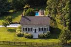 Steeped in history and transformed with impeccable taste, The 1799 House is where 18th-century craftsmanship meets modern elegance. Built in 1799 and thoughtfully restored, this historic gem in Dutchess County now pairs its historic soul with refined, design-forward living. Set on 1.7 private acres in the Town of Poughkeepsie with easy access to Metro-North, Amtrak, and a 90-minute drive to NYC, the home unfolds with the quiet confidence of a property where every choice is intentional. Just three miles from Vassar College â€” with its nationally recognized arboretum, historic architecture, and year-round cultural programming â€” it offers a rare blend of natural beauty and intellectual vibrancy. Its current stewards have layered in rich Farrow & Ball hues, curated lighting from Roll & Hill, Flos, and Fritz Hansen, and a harmonious palette of textures and materials that elevates every room. Original wide-plank floors, tall ceilings, and period fireplaces anchor the home in its heritage, while the flowing layout and bespoke finishes speak to modern sensibilities.The light-filled kitchen, with stainless steel appliances and a gas range, blends seamlessly with the homeâ€™s character while offering modern function. The beautifully appointed dining and living rooms â€” each with newly refurbished gas fireplaces â€” are connected by a gracious center hall. Off the living room, a private office provides a quiet spot for working from home. Upstairs, the three bedrooms include a primary suite with ensuite bath and a private workout room that could also serve as a second home office. One bedroom is currently appointed as an inviting media room, anchored by a luxe RH sectional sofa paired with mid-century leather chairs. Outside, the grounds have been transformed into a private oasis. A saltwater, heated pool is framed by bluestone walls and a herringbone brick surround, with stone steps leading from the back patio â€” also in herringbone brick. The fully fenced backyard is bordered by abundant hydrangea, lily, and iris blooms, creating a lush seasonal backdrop. A terraced waterfall trickles down to a small pool stocked with goldfish, adding a tranquil note to the landscape. The propertyâ€™s story reaches back to the homeâ€™s construction in 1799, when it stood as part of a larger rural holding in what would later become part of Poughkeepsie. By the mid-19th century, that land was acquired by John Roach, a pioneering shipbuilder and industrialist who rose from humble beginnings in Ireland to become the largest shipbuilder in the United States. His legacy â€” and his connection to this land â€” endure as part of the homeâ€™s rich narrative. Today, Poughkeepsie is writing an exciting new chapter. It offers a rare mix of college-town vitality, peaceful neighborhoods, and proximity to New York City. The Urban Trail Project links parks, landmarks, and the Walkway Over the Hudson, the worldâ€™s longest elevated pedestrian bridge. Nearby, Eastdale Village brings together dining, shopping, and community events in a walkable, thoughtfully planned setting, with restaurants, cafes, specialty shops, and gathering spots for markets and festivals. Developments such as the Hudson Heritage project and the new boutique Heartwood at Vassar hotel are further shaping the cityâ€™s future. With $10 million in Downtown Revitalization Initiative funding fueling growth, Poughkeepsie is in the midst of a dynamic revival â€” making The 1799 House not only a beautiful place to live, but part of a thriving and evolving community. With updated systems, meticulous restoration, and a style that is both timeless and fresh, The 1799 House is equally suited as a full-time residence or weekend escape. Here, history is not only preserved, it is revitalized â€” much like the town it calls home. For those seeking a true turnkey property, the home can be offered with its curated furnishings and decor for an additional consideration.