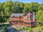 With sweeping Catskills mountain views and a design that blends rustic log home warmth with indulgent amenities, this is the kind of place you donâ€™t just seeâ€”you experience. Step inside to a vaulted great room where floor-to-ceiling windows frame the landscape like living art, and a stone fireplace anchors the space for cozy evenings. The chefâ€™s kitchen flows into a gracious dining area, making gatherings easy and memorable.The main-level primary suite is pure retreat, complete with a stone-wrapped heart-shaped jetted tub and private seating area. Upstairs, a loft and additional bedrooms offer plenty of room for guests, while downstairs is an entertainerâ€™s playgroundâ€”air hockey, foosball, a full bar, dartboards, and even a sauna, all with walk-out access to the fresh mountain air.Multiple wraparound decks, a screened-in outdoor kitchen gazebo, and lush landscaping create endless spaces to relax or celebrate. A guest house, 4-car garage, and proximity to Bethel Woods, lakes, and hiking trails add even more to love. Already an active short-term rental, itâ€™s ready to be your personal escapeâ€”or your next great investment.