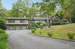 Clarkstown School District! Enjoy tranquility and privacy amidst an exceptional setting on almost 2 acres in a highly sought-after location. This extraordinary contemporary sprawling ranch has over 5, 000 sqft of living space with the main level and finished walk-out lower level combined. Featuring a 3-car attached garage, beautiful hardwood floors, dramatic cathedral ceilings, with a spacious layout and walls of windows and skylights bringing in natural light throughout. Incredible primary suite with grand bathroom including a soaking jacuzzi tub, rainhead shower, dual vanities and massive walk-in-closet with separate dressing room. 2 additional bedrooms complete the bedroom wing of the home, with a separate guest bedroom or office with sliders leading to the screened-in sunroom overlooking the park-like-grounds, lush landscaping and peaceful waters of a shared private pond. Completing the first floor is a stunning living room with soaring ceilings, dazzling chandelier and wood burning fireplace; second family room, formal dining room and a spacious eat-in-kitchen with stainless steel appliances, island centerpiece, fireplace and doors leading to the fantastic deck - amazing for entertaining! Finished walk-out lower level includes a massive space downstairs, family room, kitchenette, full bathroom with access to the attached garage. Located in the award winning Clarkstown School District and nearby shopping, parks and major highways for an easy commute!
